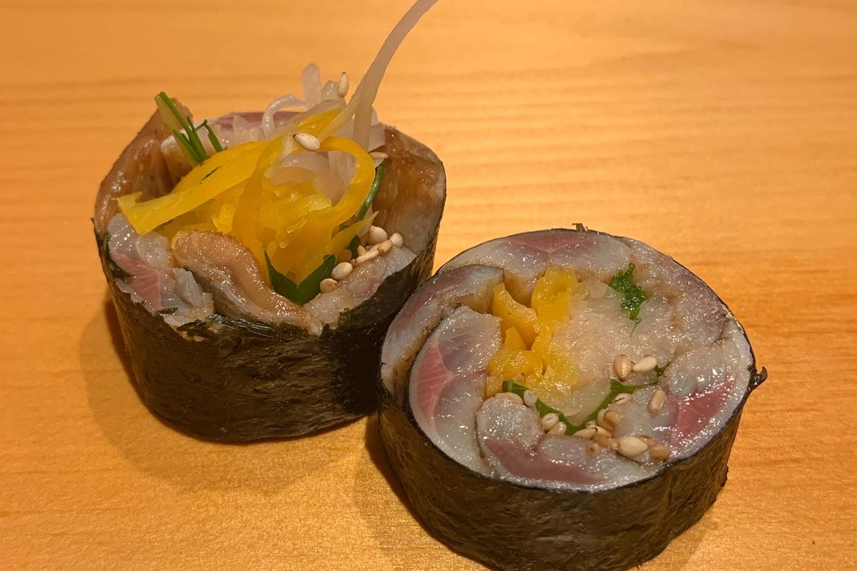 Two rounds of saba maki, mackerel rolled in nori with yellow pickle and sesame