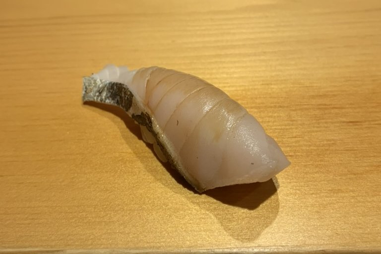 A white-fleshed sawara nigiri with a strip of skin