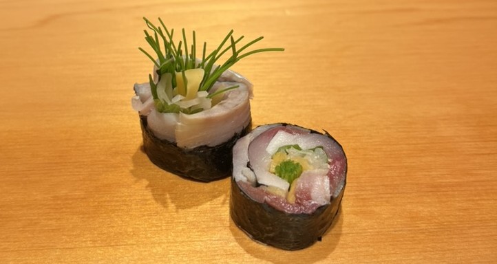 Two pieces of sushi on the counter at a Japanese restaurant