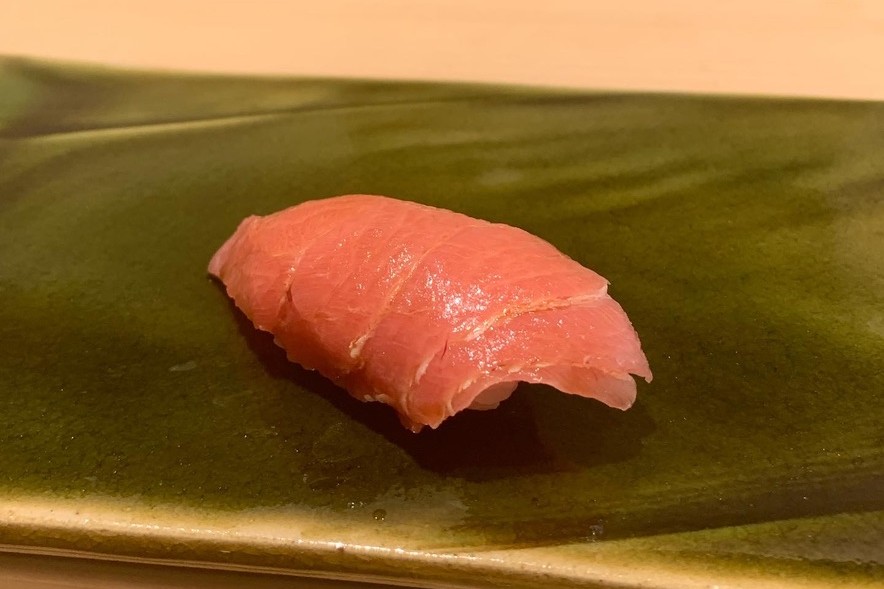 An akami nigiri, the leaner red cut of tuna, on a green oribe plate at Sushi Mizukami