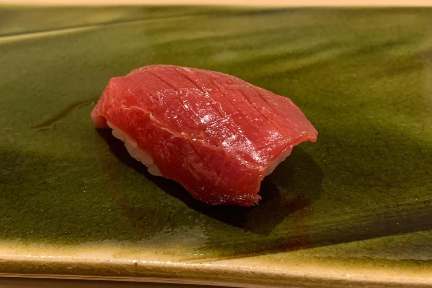 A chutoro nigiri, deep red with a sheen of fat, on a green oribe plate at Sushi Mizukami