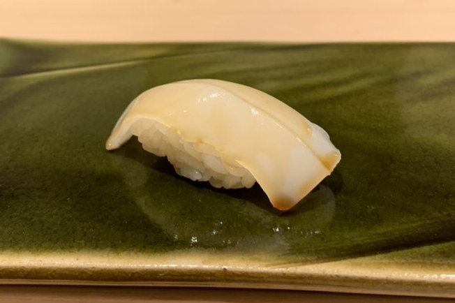 Squid nigiri on a green plate at Sushi Mizukami