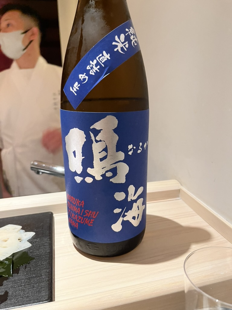 A blue-labelled bottle of Narumi junmai sake on a counter
