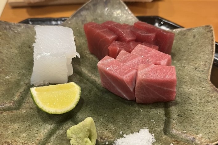 Sashimi of marbled honmaguro tuna and white squid on a leaf-shaped plate with sudachi, wasabi and salt