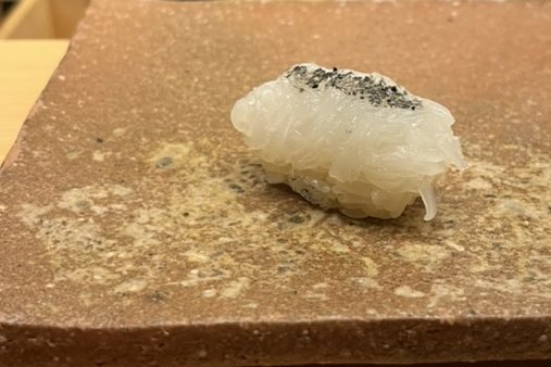 A finely cut squid nigiri seasoned with squid-ink salt
