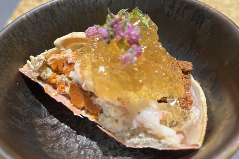 Snow crab served in its own shell with crab miso, roe and a savoury jelly, garnished with edible flowers