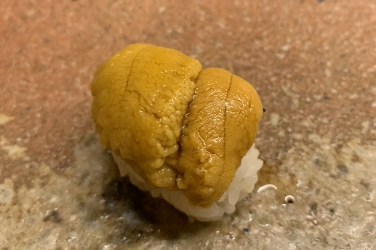 A generous uni (sea urchin) nigiri on a stone plate