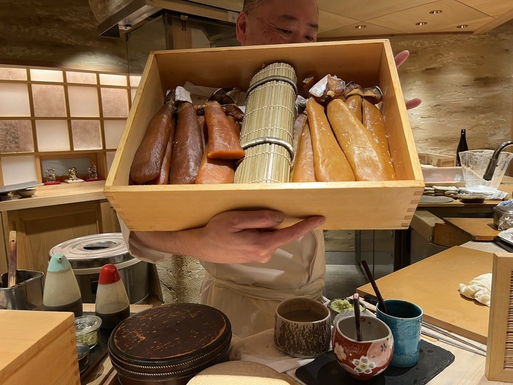 Chef Satō presenting a cypress box of cured and marinated fish at Sushi Ei