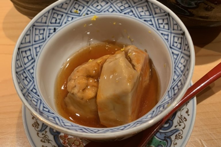 Steamed abalone in a bowl of amber liver sauce