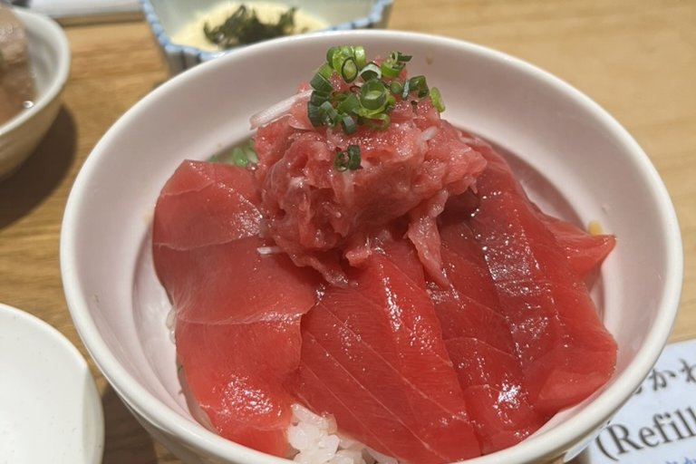 A bowl of Yamayuki tuna over rice, akami slices with a mound of minced toro and scallion