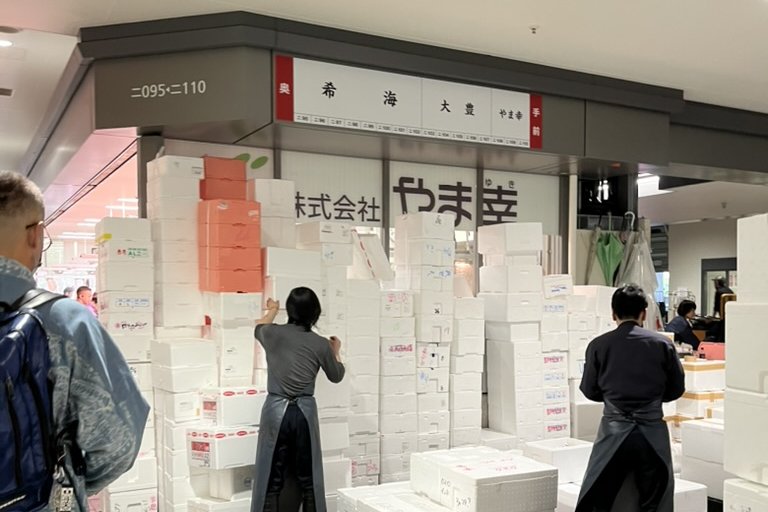The Yamayuki stall at Toyosu market, sign reading Yamayuki, with workers in aprons among stacks of styrofoam boxes