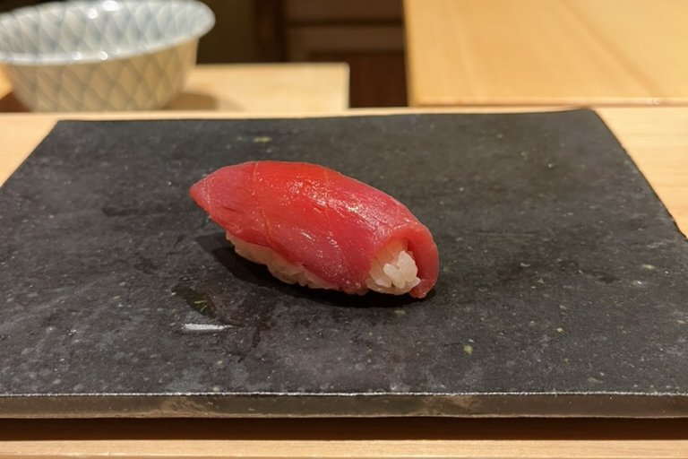 An akami nigiri, lean red tuna on slate